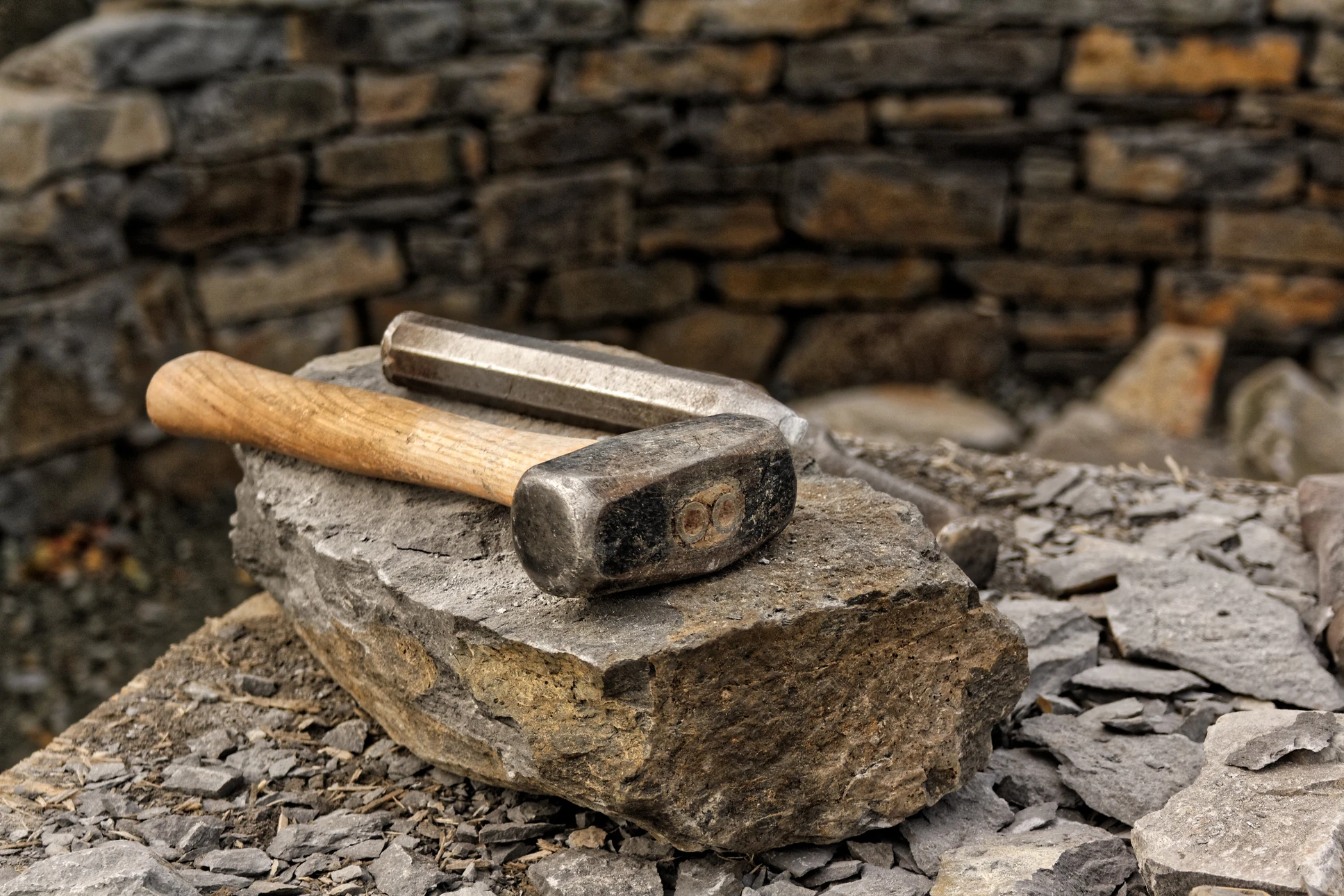Maison traditionnelle anglaise à toit de chaume dans jardin paysager avec bancs en bois et bassin décoratif