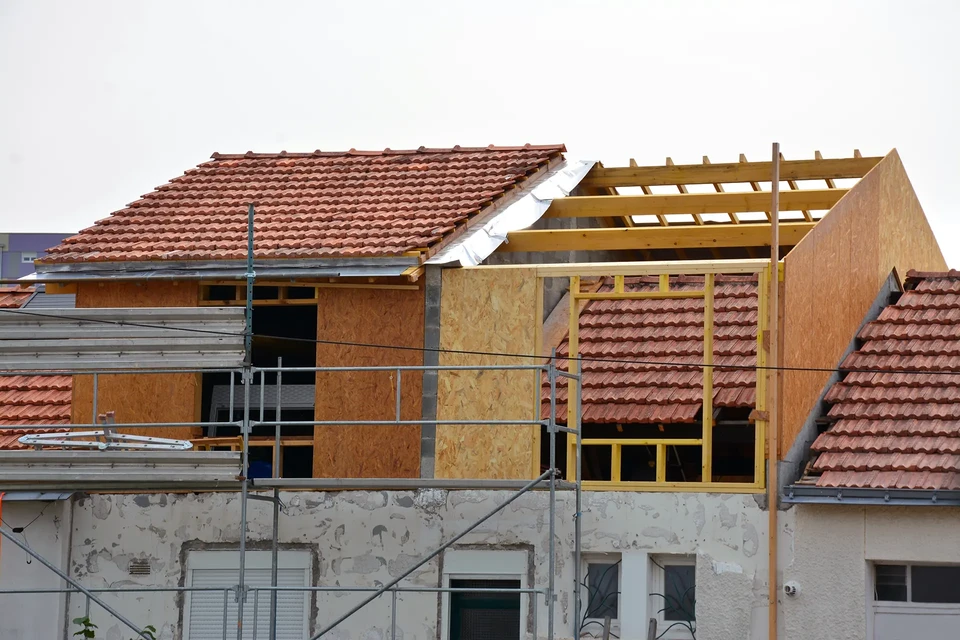 Deux habitations géodésiques modernes aux façades angulaires grises implantées sur terrain vallonné herbeux