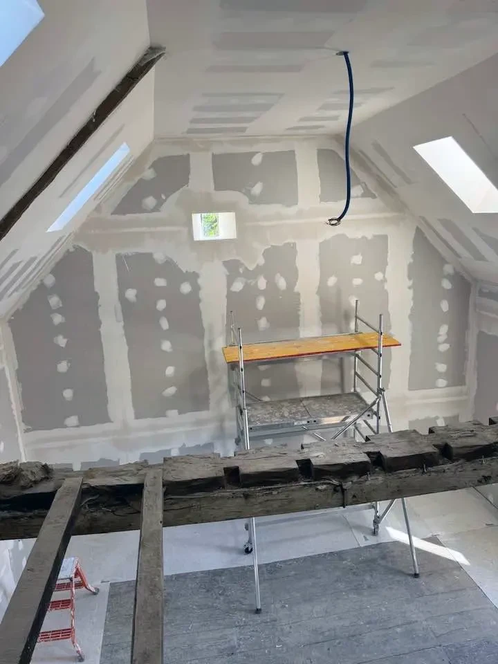 Cuisine moderne ouverte avec îlot central, sièges filaires métalliques, suspensions design