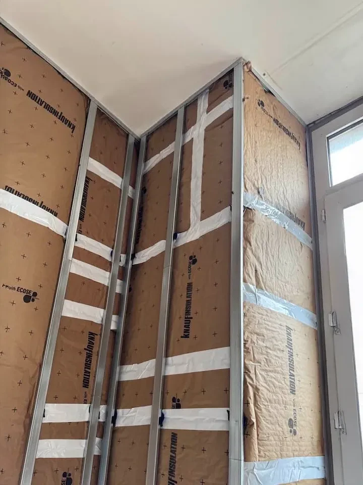 Combles aménagés en cours de finition avec charpente bois apparente et cloisons blanches