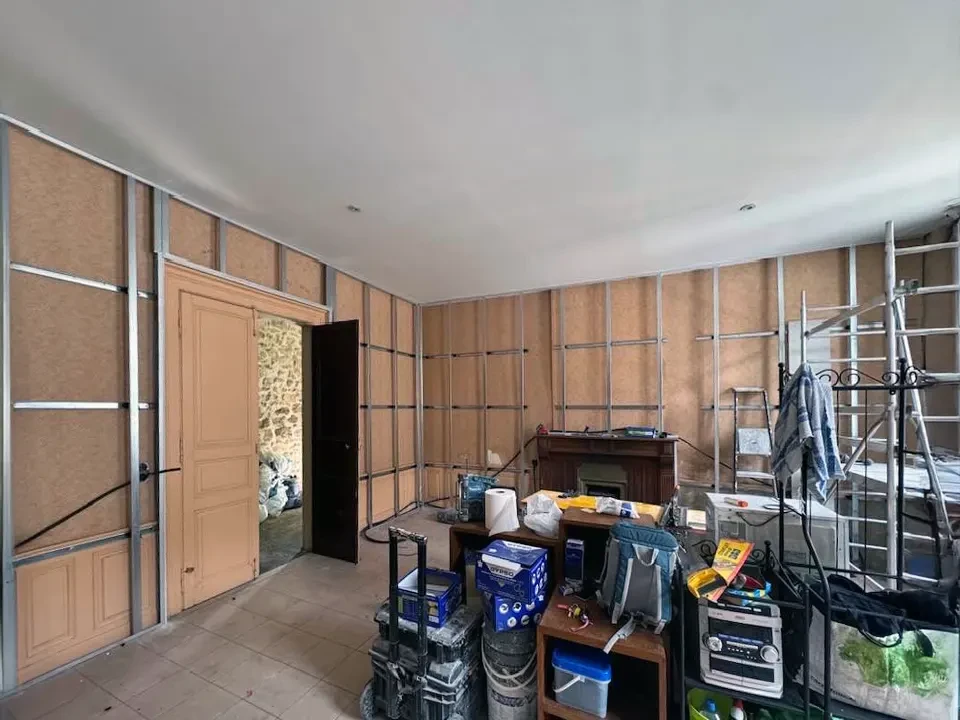 Un homme prépare une planche laminée pour l'installation du sol dans l'appartement en cours de rénovation