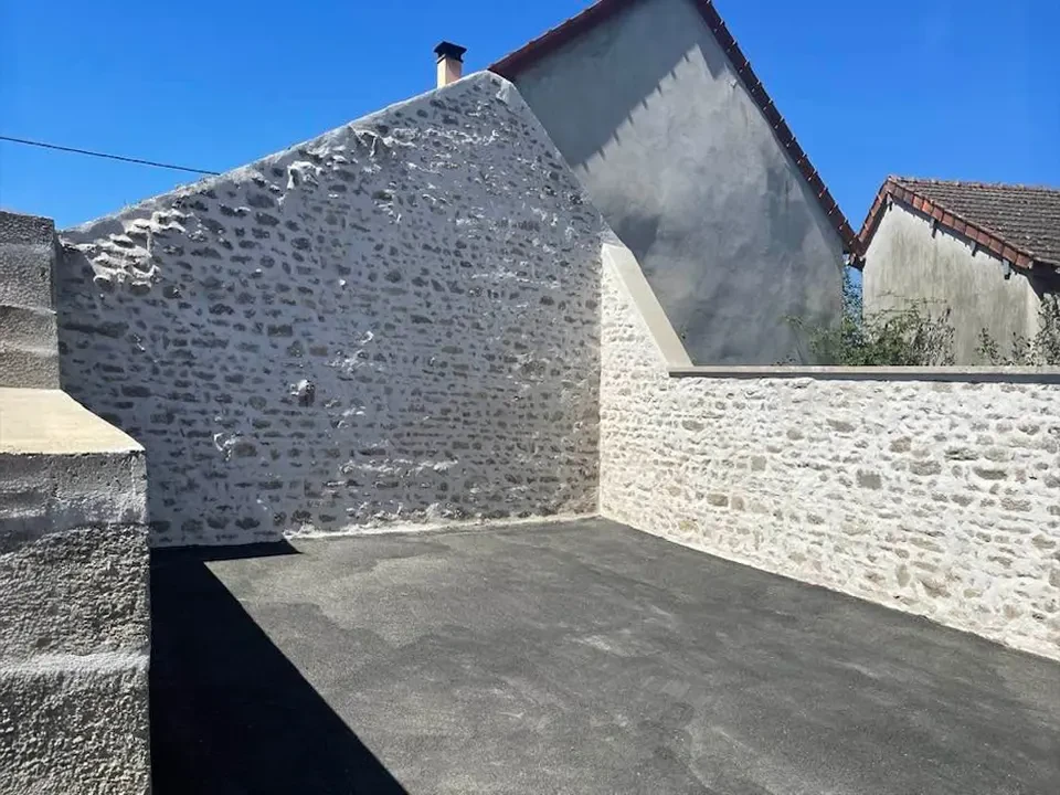 Paysage rural montagnard avec mur en pierres sèches traditionnel traversant une prairie d'herbes hautes jaunies