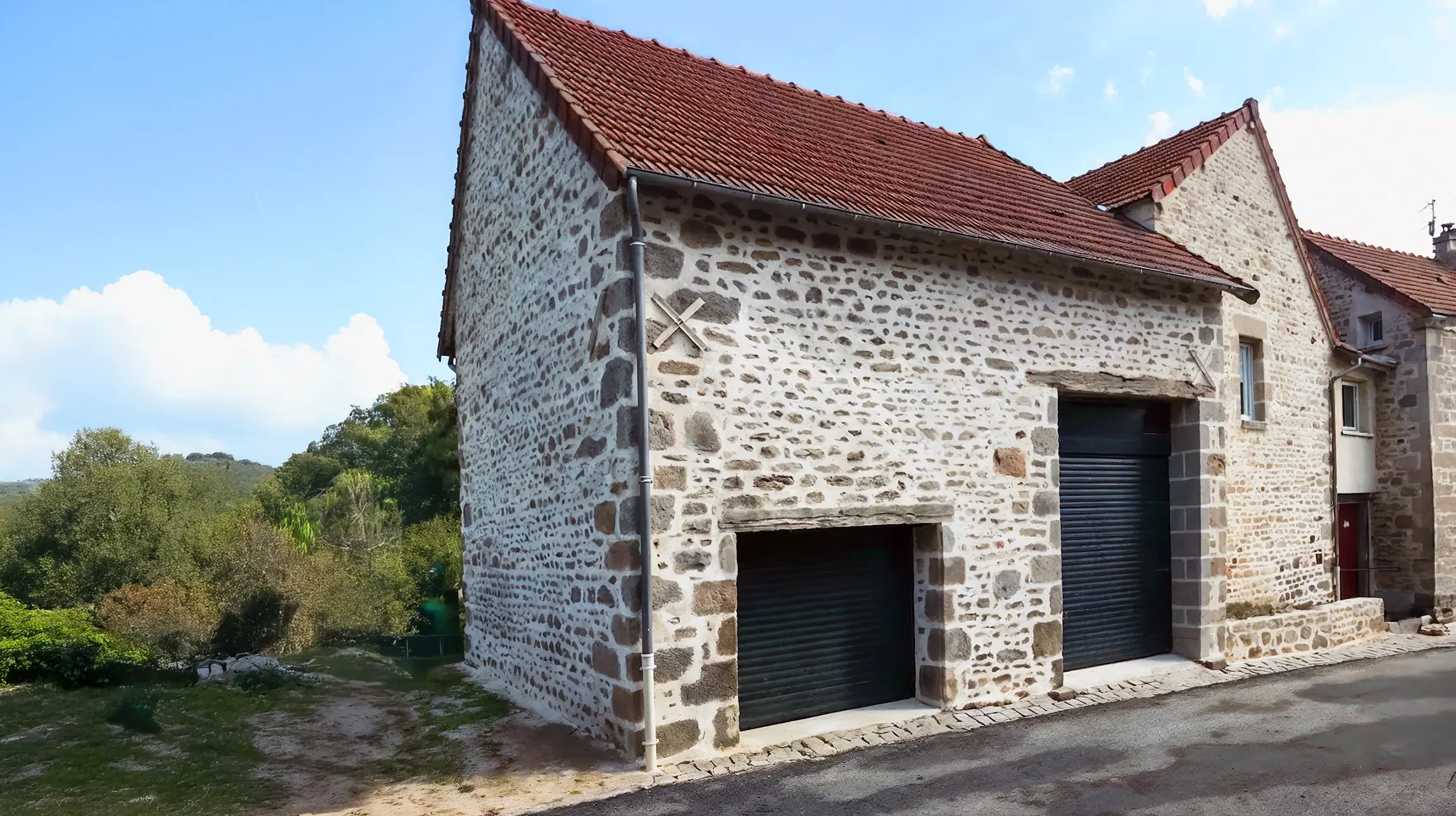 Mur en pierre naturelle présentant un assemblage de blocs rectangulaires et carrés de différentes tailles, disposés selon un appareillage irrégulier