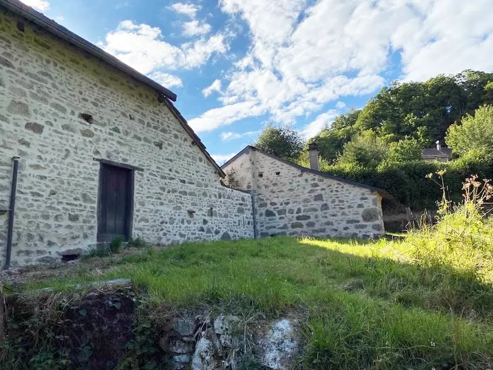 Extérieur d'un bâtiment en pierre calcaire avec grande porte double en bois massif sous arc en briques rouges